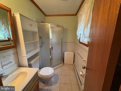 a white toilet sitting next to a bathroom sink and a shower