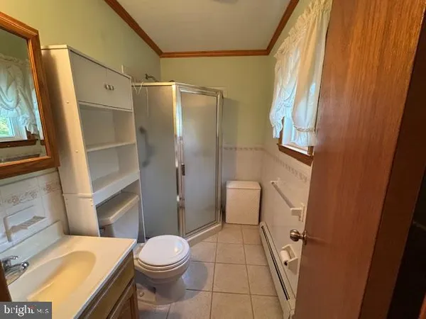 a white toilet sitting next to a bathroom sink and a shower
