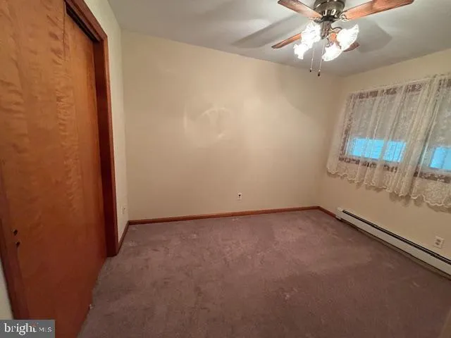 an empty room with a ceiling fan and a window