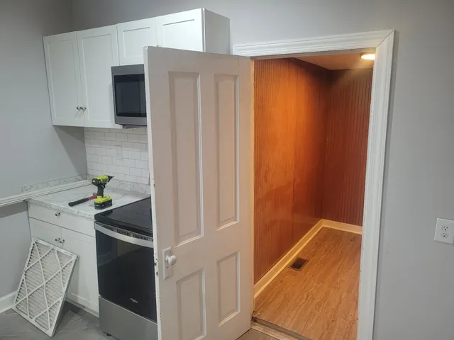 a kitchen with white cabinets and white appliances