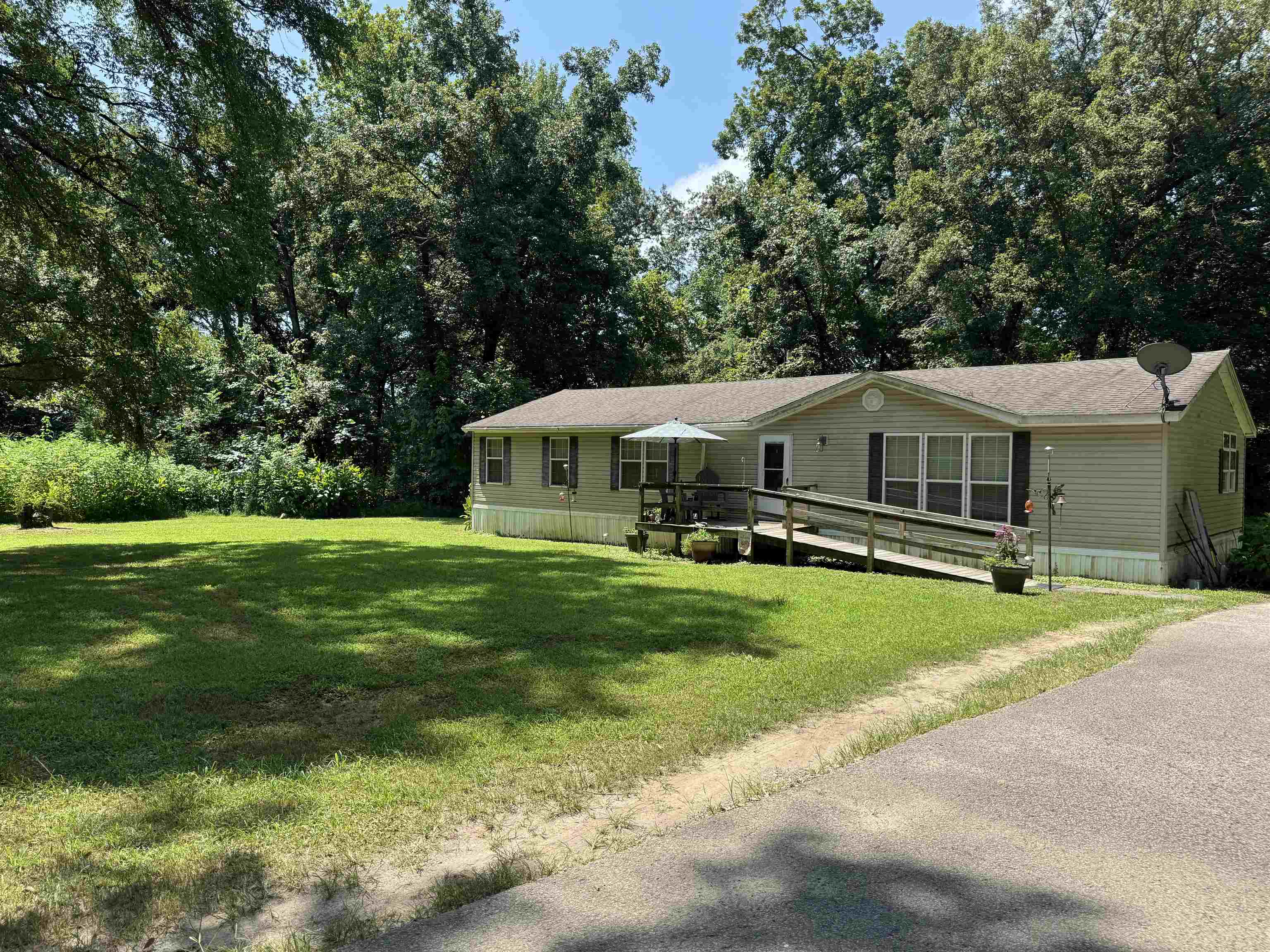 12775 Seward Road Eads, TN 38028 - Photo 3 of 4 Manufactured / mobile home featuring a front yard, view of wooded area, and a wooden deck