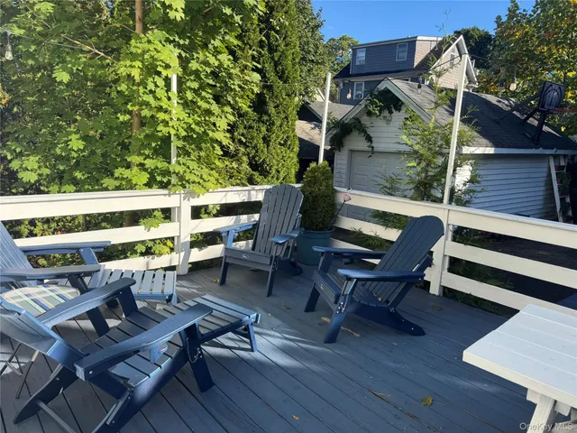 a backyard of a house with wooden floor outdoor seating and yard in the back