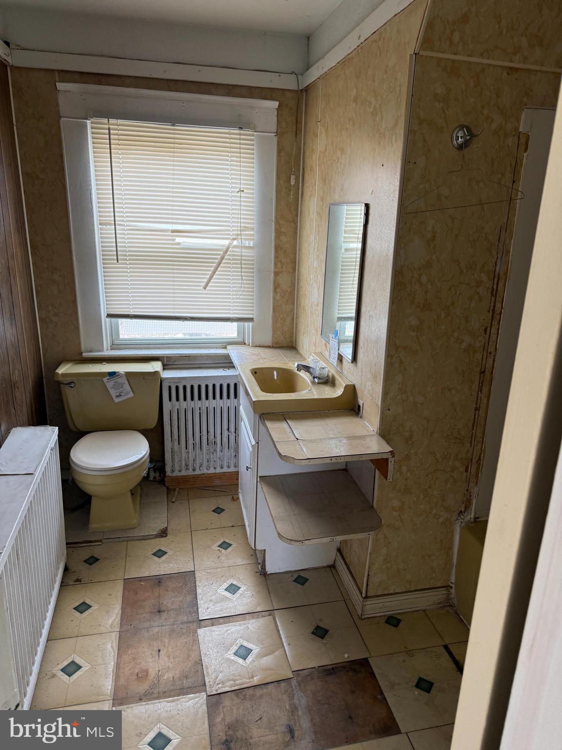 900 North Point Road Baltimore, MD 21224 - Photo 9 of 12 a bathroom with a toilet a sink and a mirror