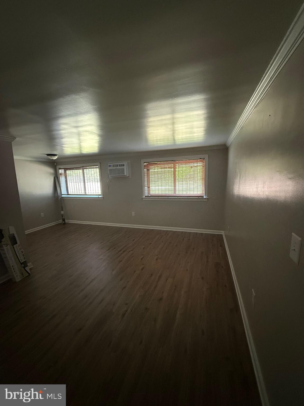 3105 Naylor Road Southeast, Unit 104 Washington, DC 20020 - Photo 12 of 12 an empty room with wooden floor and windows