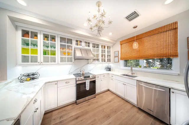 a kitchen with stainless steel appliances a sink stove and cabinets