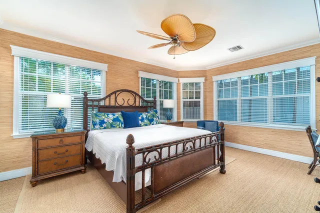 a bedroom with a bed and large windows