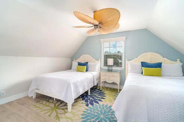 a bedroom with a bed a chair and a chandelier