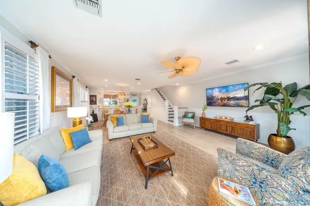 a living room with furniture floor to ceiling window and a flat screen tv