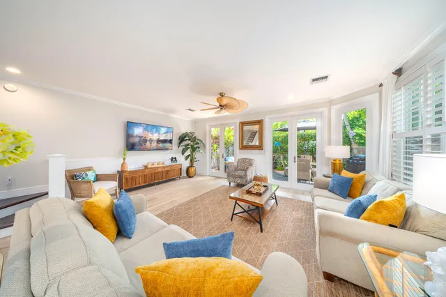 a living room with furniture kitchen view and a large window
