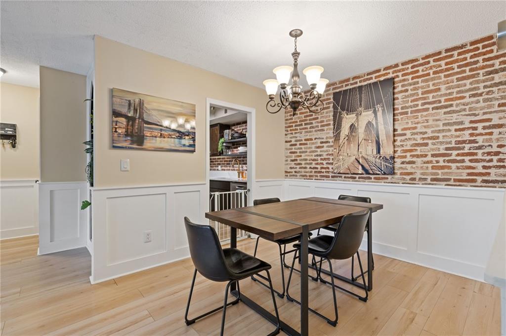 6851 Roswell Road, Unit N9 Atlanta, GA 30328 - Photo 11 of 16 a view of a dining room with furniture wooden floor and chandelier