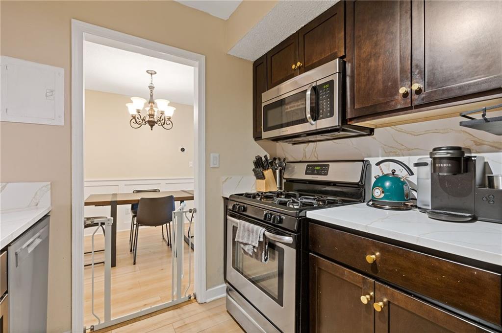 6851 Roswell Road, Unit N9 Atlanta, GA 30328 - Photo 10 of 16 a kitchen with stainless steel appliances granite countertop a stove and a microwave