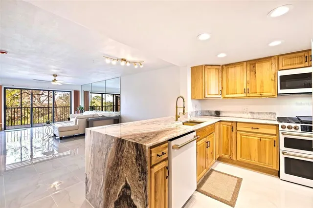 a view of a kitchen with a refrigerator and a stove top oven