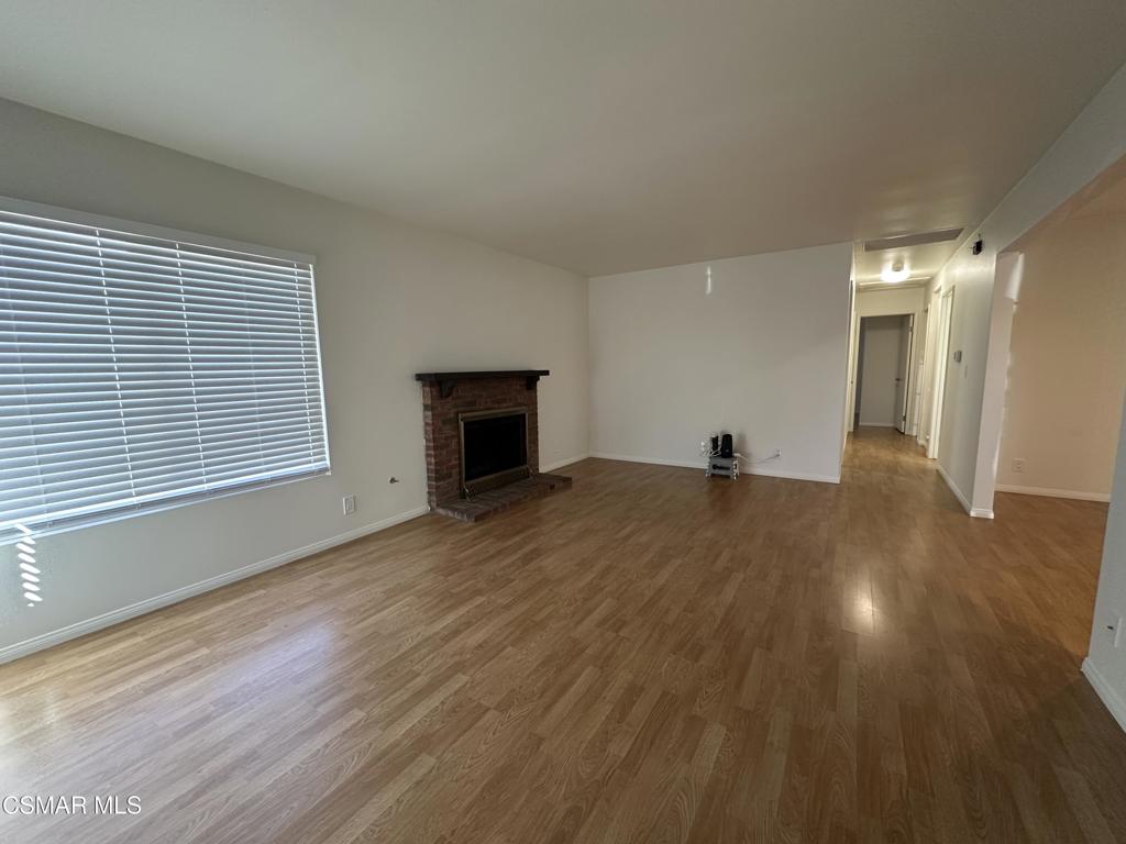 6495 Hope Street Simi Valley, CA 93063 - Photo 4 of 33 a view of empty room with wooden floor and fireplace