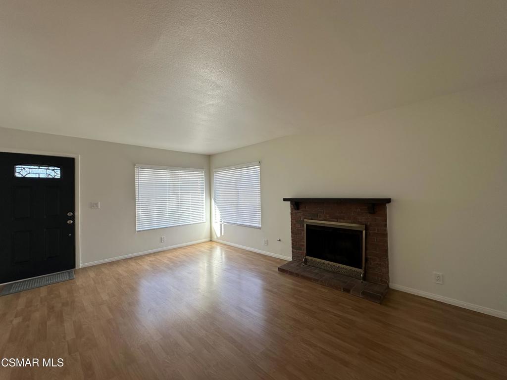 6495 Hope Street Simi Valley, CA 93063 - Photo 5 of 33 an empty room with wooden floor fireplace and windows