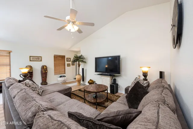 a living room with furniture a flat screen tv and a window