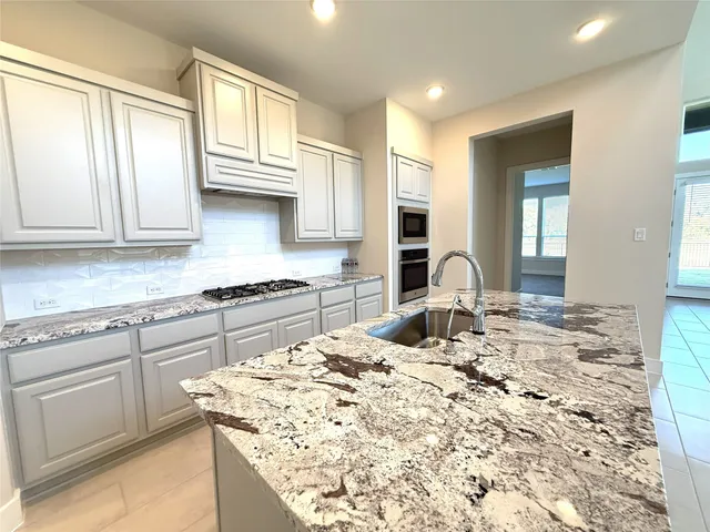 a kitchen with a stove top oven and a sink
