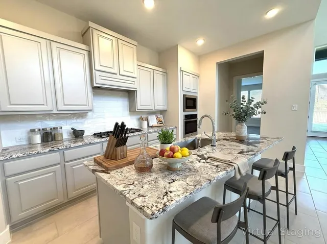 a kitchen with a table chairs and white cabinets