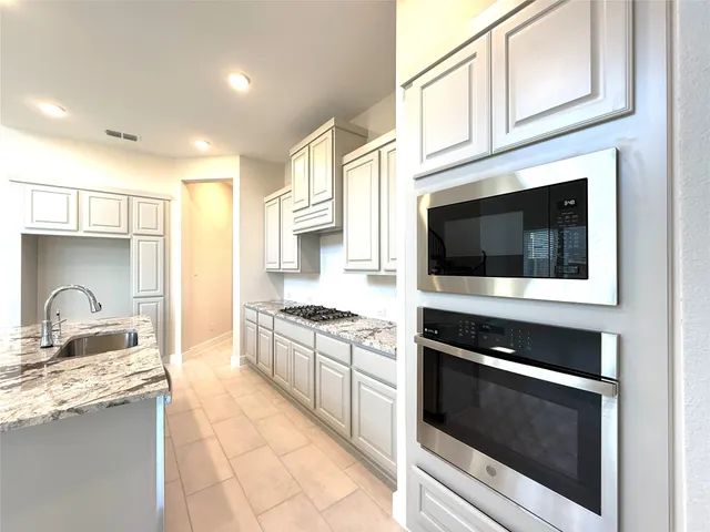 a kitchen with stainless steel appliances granite countertop a stove and a microwave