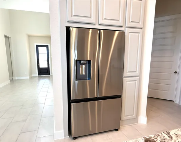 a view of kitchen with refrigerator and cabinet