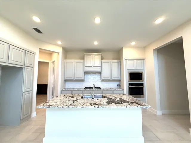 a kitchen with kitchen island a sink stainless steel appliances and cabinets