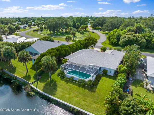 an aerial view of residential houses with outdoor space and swimming pool