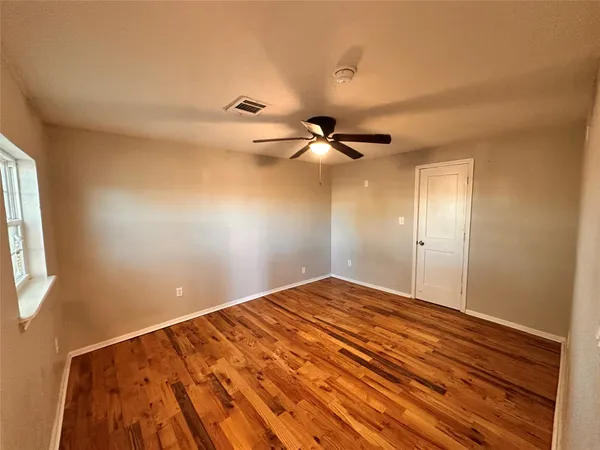 a view of empty room with a window and ceiling fan