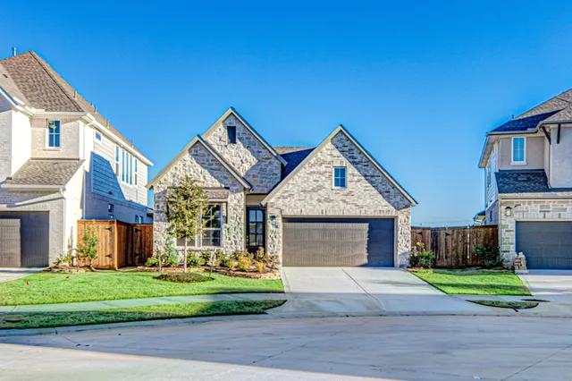 a front view of a house with a garden and yard