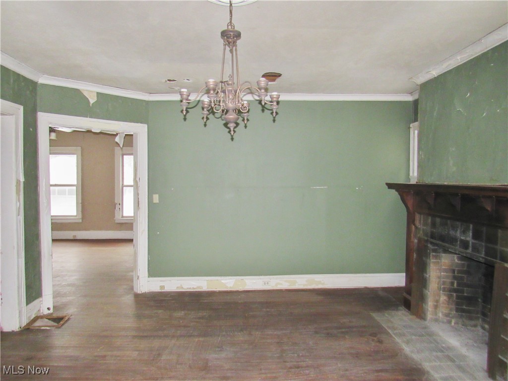 14450 Superior Road Cleveland, OH 44118 - Photo 5 of 35 Unfurnished dining area featuring wood finished floors, baseboards, and an inviting chandelier