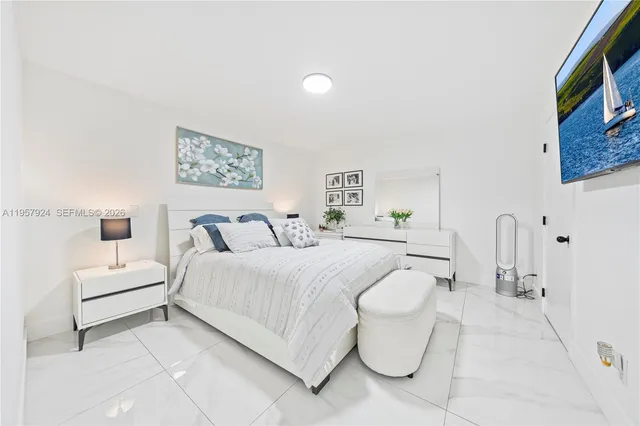 a spacious bedroom with a bed and white couch