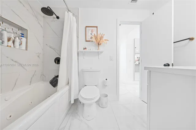a bathroom with a bathtub toilet and shower