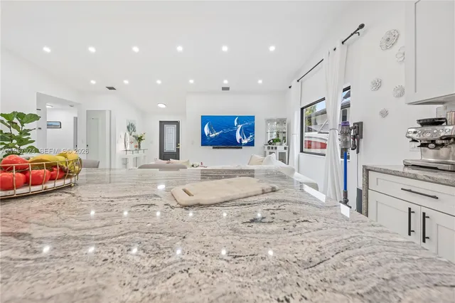a large bedroom with a bed and a view of living room