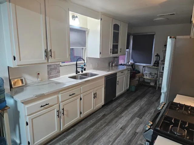 a kitchen with granite countertop a stove and a refrigerator