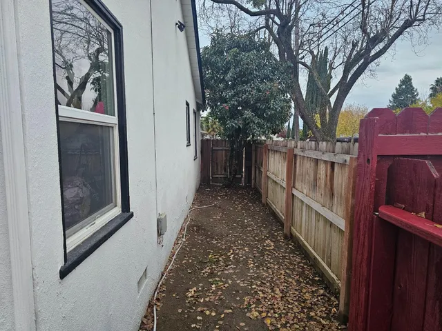 a view of a pathway of a house with wooden fence