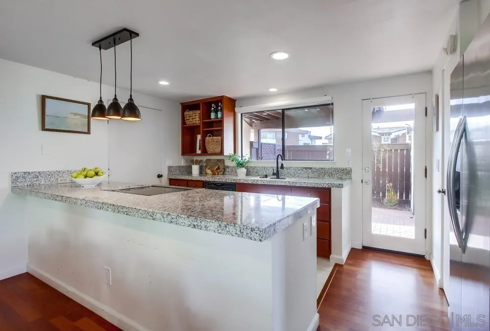 141 Sea Cliff Way Del Mar, CA 92014 - Photo 11 of 65 a kitchen with stainless steel appliances granite countertop a sink a stove and a wooden floor