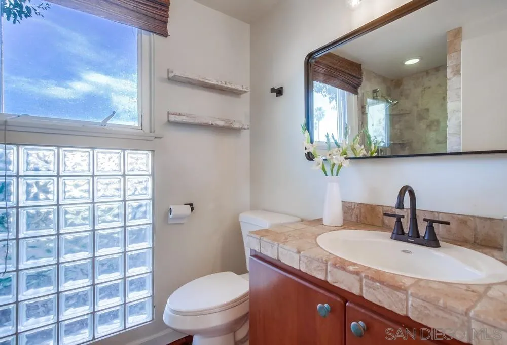 141 Sea Cliff Way Del Mar, CA 92014 - Photo 24 of 65 a bathroom with a granite countertop sink a toilet and a mirror