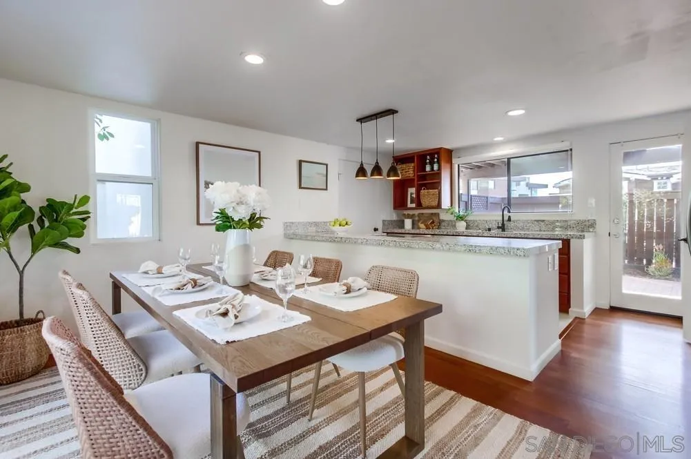 141 Sea Cliff Way Del Mar, CA 92014 - Photo 9 of 65 a kitchen with a sink a stove a kitchen island with chairs and wooden floor