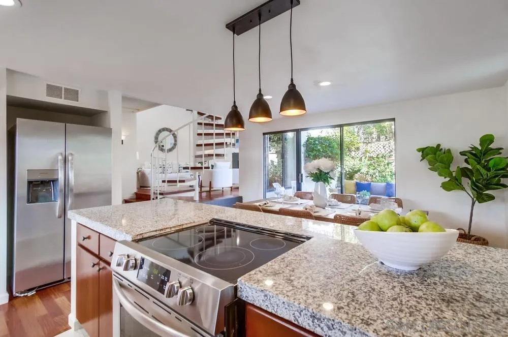 141 Sea Cliff Way Del Mar, CA 92014 - Photo 10 of 65 a kitchen with stainless steel appliances granite countertop a sink a stove and a wooden floors