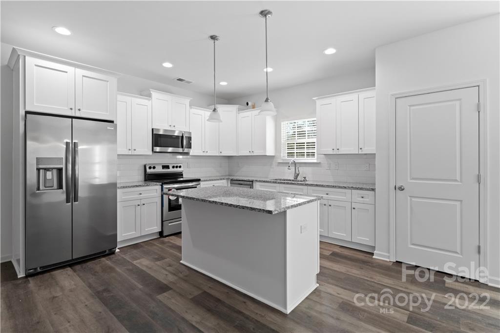 808 McDonald Road Charlotte, NC 28214 - Photo 6 of 30 a kitchen with stainless steel appliances granite countertop a refrigerator a sink dishwasher a stove and white cabinets with wooden floor