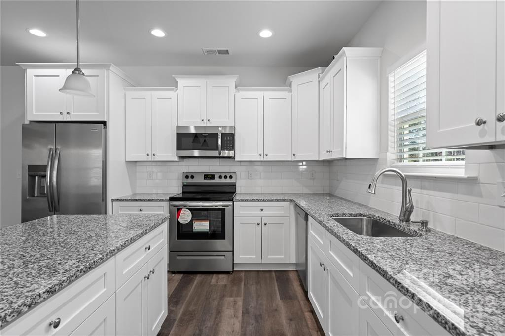 808 McDonald Road Charlotte, NC 28214 - Photo 7 of 30 a kitchen with kitchen island granite countertop a sink stainless steel appliances and white cabinets
