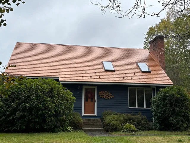 a view of house with garden and a tree