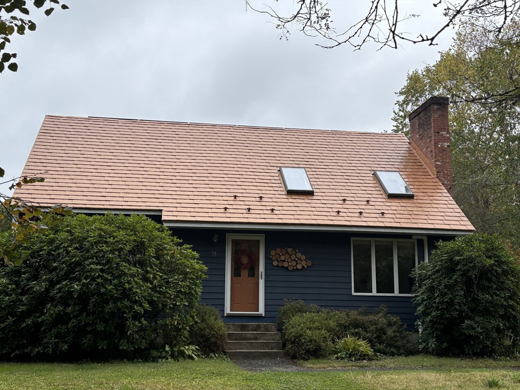 a view of house with garden and a tree