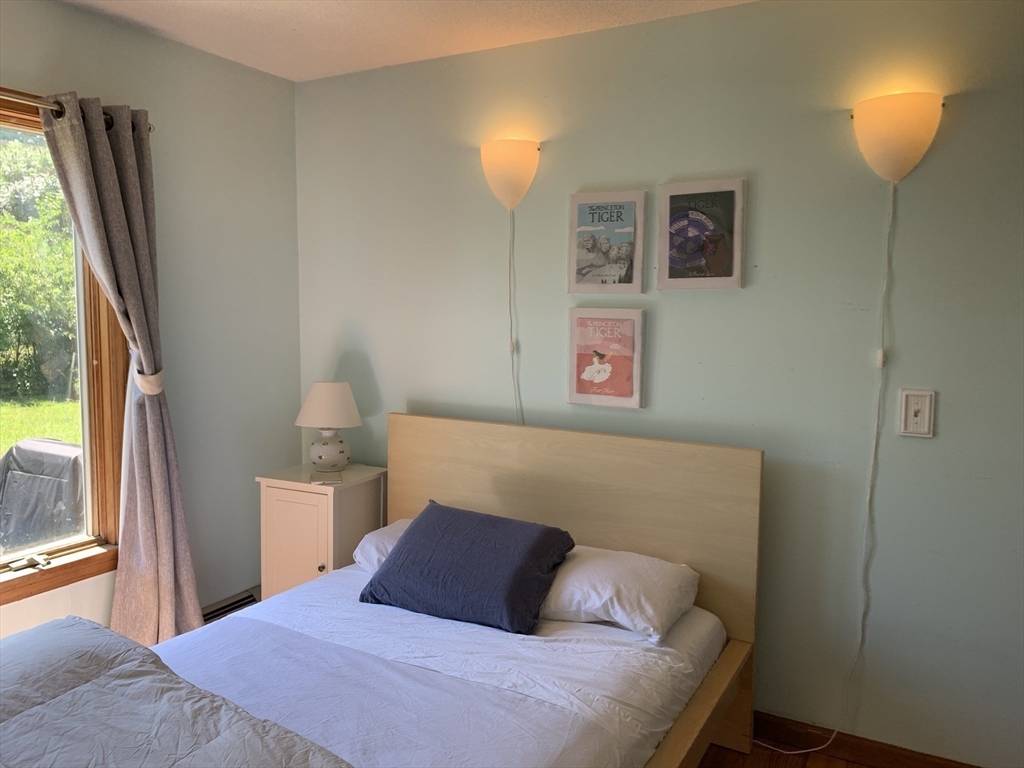 75 State Street Amherst, MA 01002 - Photo 20 of 39 a bedroom with a bed and a lamp next to a window