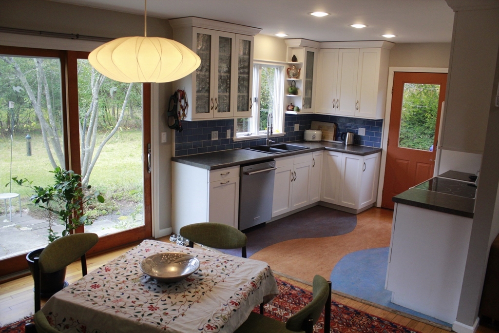 75 State Street Amherst, MA 01002 - Photo 9 of 39 a kitchen with stainless steel appliances granite countertop a stove a refrigerator a sink a dining table and chairs