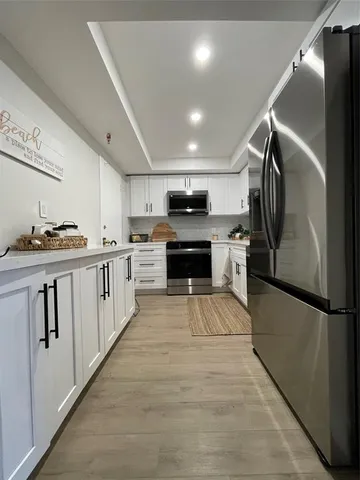 a kitchen with stainless steel appliances granite countertop a refrigerator a stove and a sink