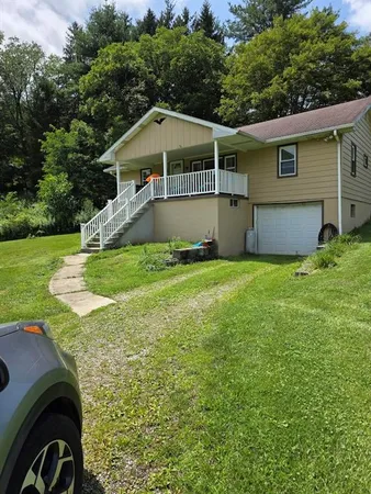a house with green field in front of it