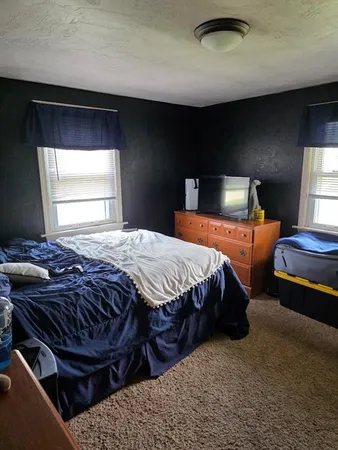a bedroom with bed and window