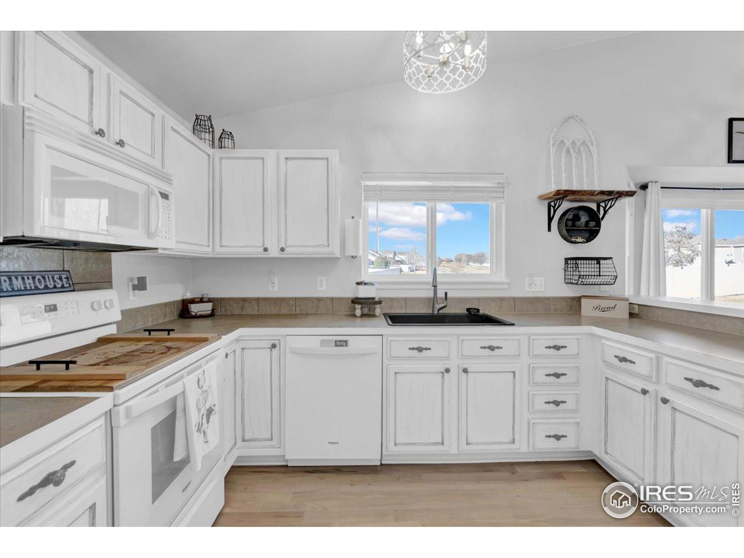 3411 Riesling Court Evans, CO 80634 - Photo 12 of 43 a kitchen with granite countertop a sink a stove and cabinets
