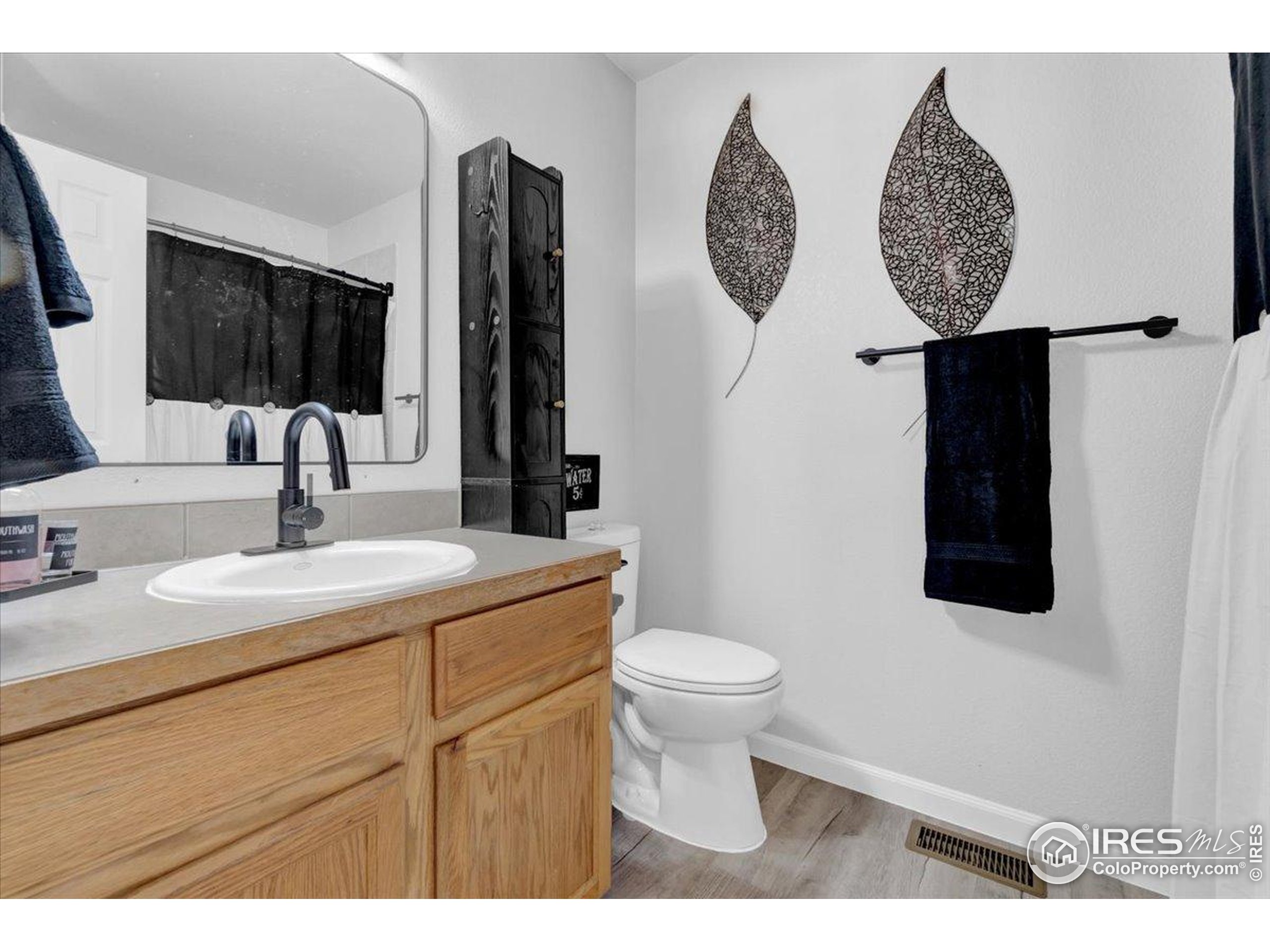 3411 Riesling Court Evans, CO 80634 - Photo 16 of 43 a bathroom with a toilet sink and mirror