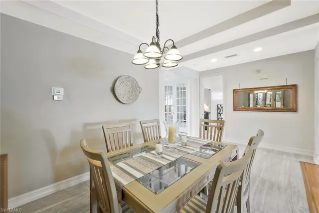 a view of a dining room with furniture a chandelier and wooden floor