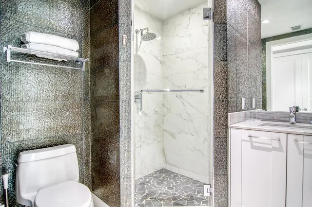a bathroom with a granite countertop toilet a sink and a mirror
